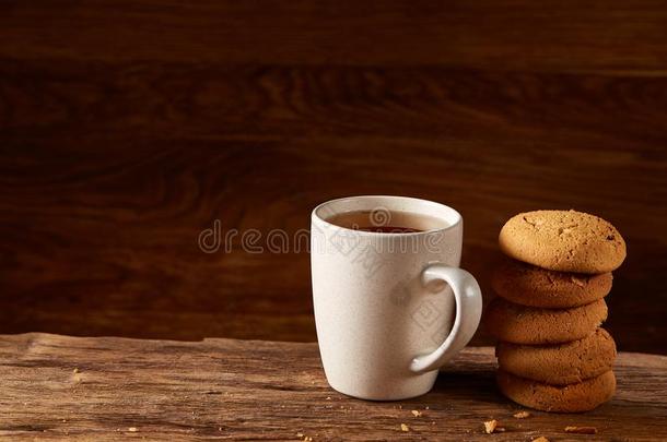 白色的瓷马克杯关于茶水和甜的甜<strong>饼干</strong>向块关于木材oval卵形的