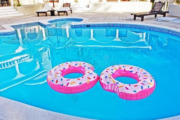 两个粉红色的浮动戒指采用一游泳水池
