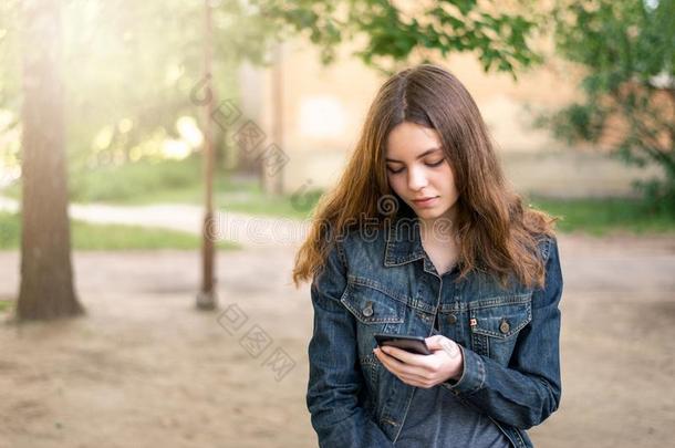 漂亮的青少年女孩使用电话采用社会的媒体