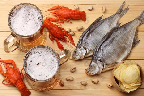 玻璃啤酒和小龙虾和干燥的鱼向光木制的后台
