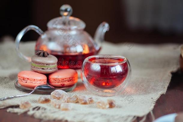 富有色彩的马卡龙和杯子关于茶水和茶水pot向木制的后台