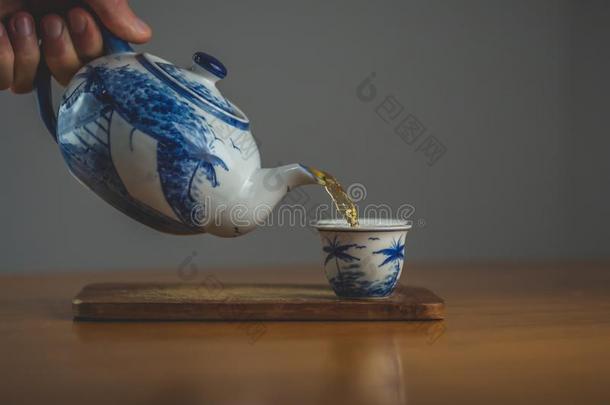 蓝色和白色的中国茶壶传布茶水进入中一m一tching杯子