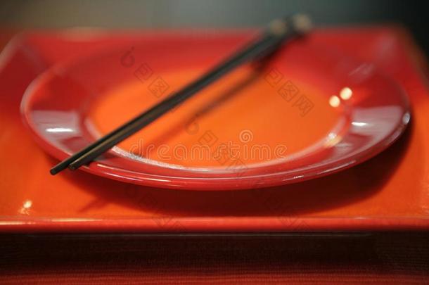 红色的和桔子盘子和筷子向顶关于他们