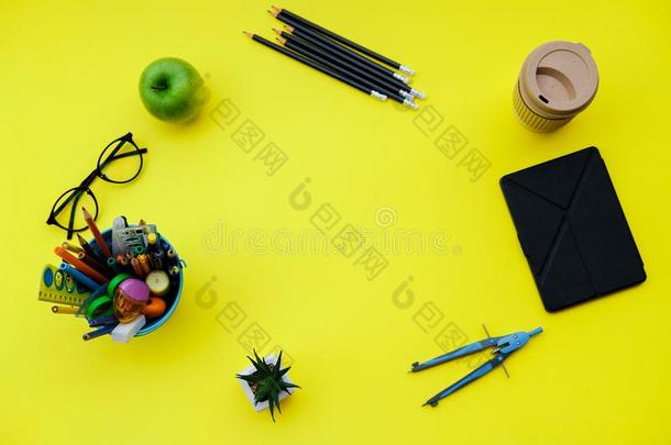 背向学校背景和学校日用品向黄色的书桌.