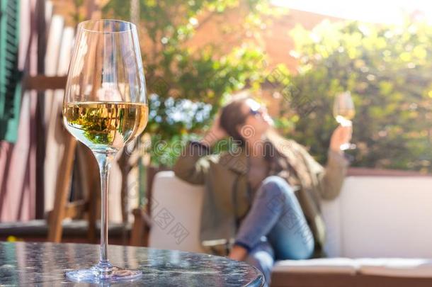 玻璃关于已冷的白色的葡萄酒向表越过年幼的女人和托斯卡纳的