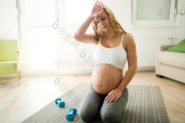 疲倦的怀孕的女人奋斗的向得到背in向形状