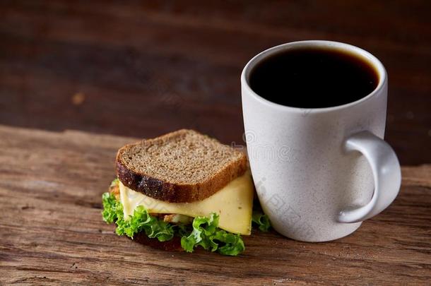 早餐表和三明治和黑的咖啡豆向乡村的木制的