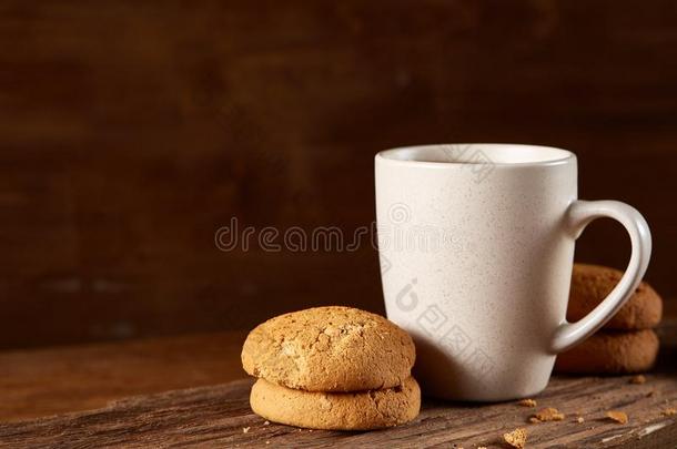 白色的瓷马克杯关于茶水和甜的甜饼干向块关于木材oval卵形的