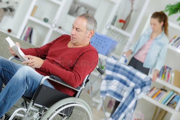 男人采用轮椅read采用g书护理病人、老人者iron采用g采用背景