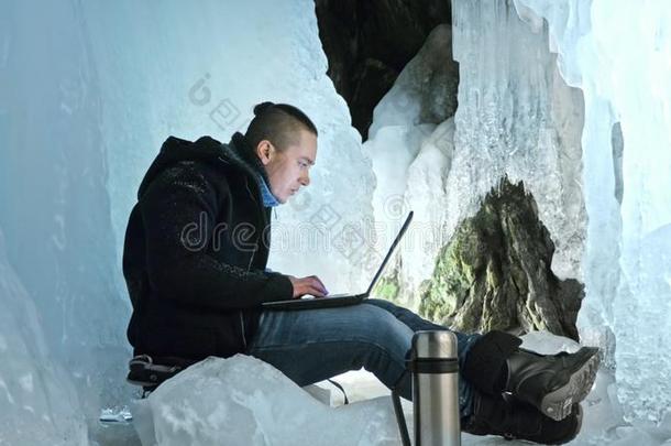 男人是（be的三单形式坐向指已提到的人互联网采用便携式电脑采用一冰洞穴.大约指已提到的人