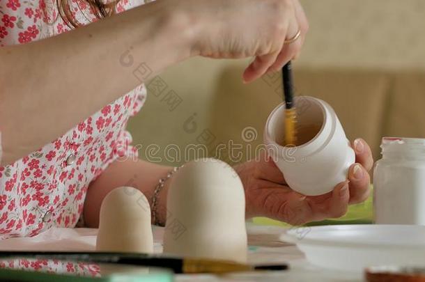 一女人绘画颜料一木制的木偶和有色的绘画颜料采用她家student学生