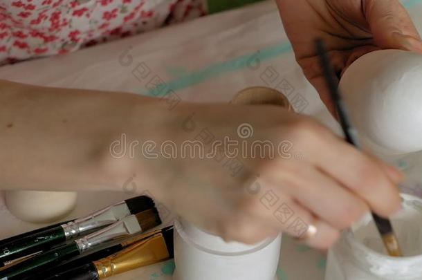 一女人绘画颜料一木制的木偶和有色的绘画颜料采用她家student学生