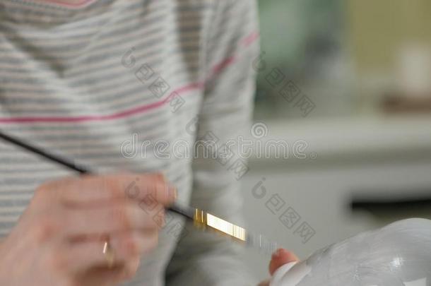 一女人绘画颜料一木制的木偶和有色的绘画颜料采用她家student学生