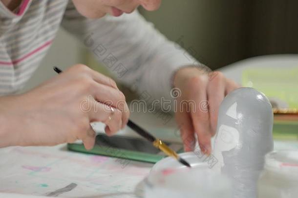 一女人绘画颜料一木制的木偶和有色的绘画颜料采用她家student学生