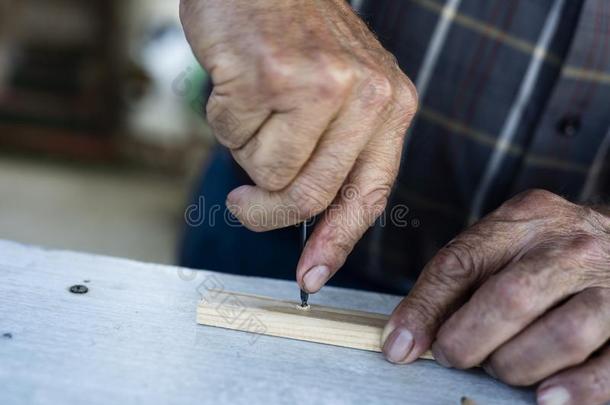 老的男人<strong>演练</strong>一木材剥光和一手钻