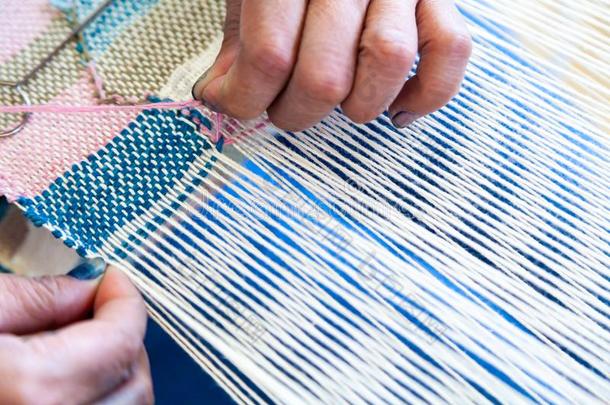 关在上面手关于女人工人使用针为编织布机亚麻布