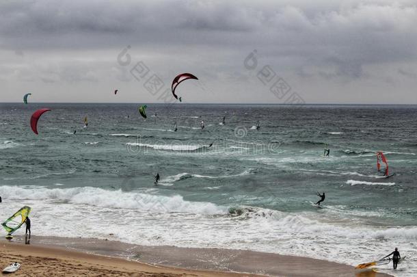 冲浪者在金秋海滩在下面多云的天采用葡萄牙