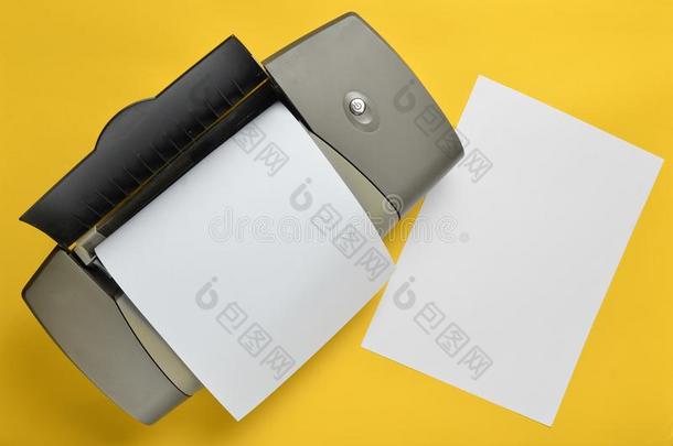 一打印机和空白的纸形状向一黄色的b一ckground.顶竞争
