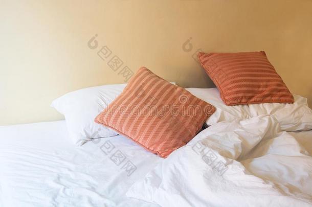 白色的枕头和桔子枕头向床和和皱纹凌乱的beta-lactamase内酰胺酶
