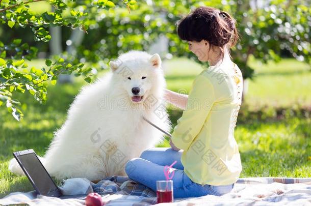 一女孩是（be的三单形式给食她狗采用一p一rk向一野餐郊游.