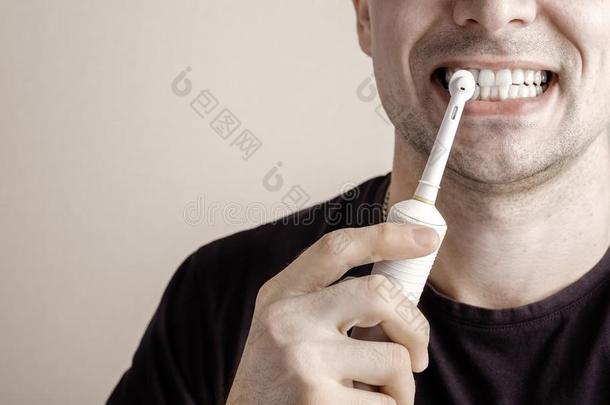 男人清洁牙和电的牙刷子