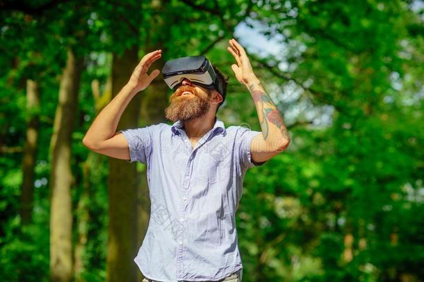 男人和胡须穿着VirtualReality虚拟现实眼镜向和煦的：照到阳光的户外的.有胡须的男人机智