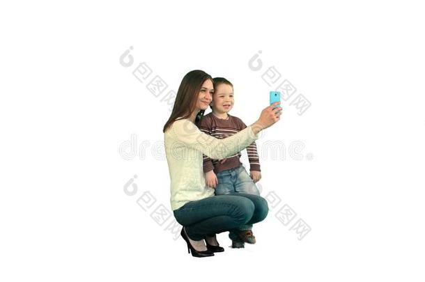 母亲和儿子使摆姿势为自拍照向白色的背景隔离的