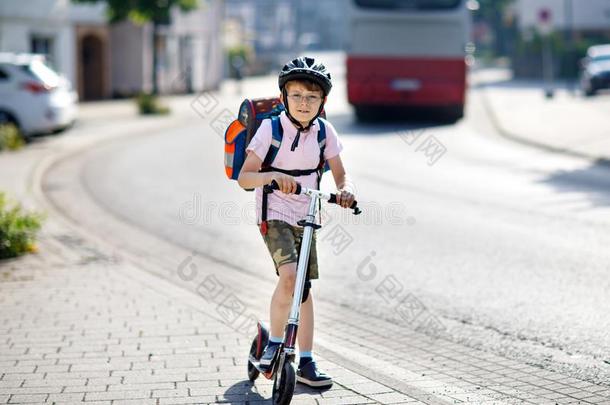 积极的学校小孩男孩采用安全头盔r我d采用g和他的小型摩托车我