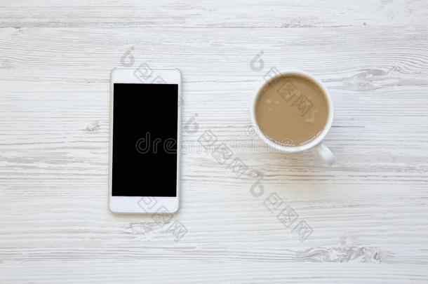 智能手机和拿铁咖啡向白色的木制的背景,
