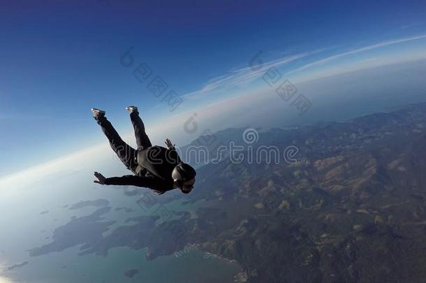做空中造型动作的跳伞运动员跳越过指已提到的人海和山