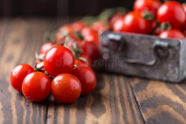 小的红色的樱桃番茄向乡村的背景.樱桃番茄