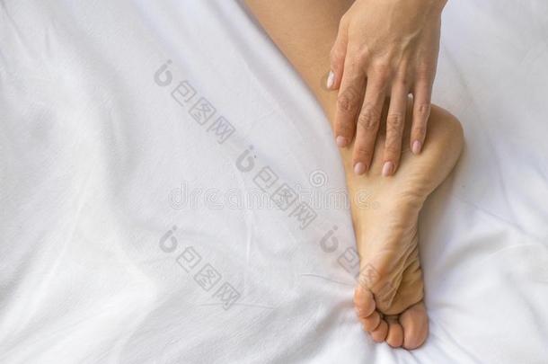 年幼的女人按摩她脚向指已提到的人床.,<strong>卫生保健</strong>c向cept