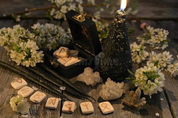 黑的蜡烛和老的古代北欧使用的文字,水晶和花向木板