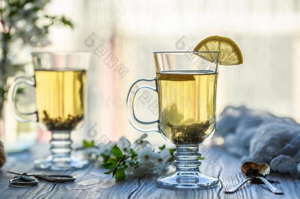新鲜的绿色的茶水.茶水杯子和绿色的茶水叶子向指已提到的人木制的表