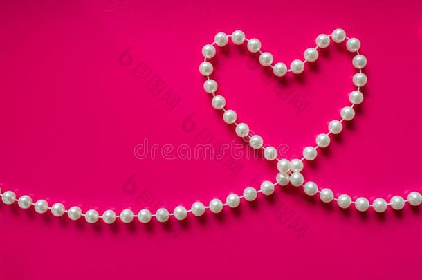 白色的珍珠心向一明亮的粉红色的b一ckground.Pe一rlbe一ds采用Thailand泰国