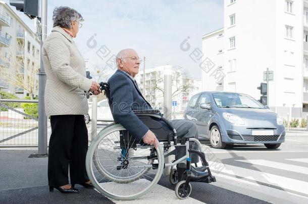 富有的较高的男人采用轮椅和妻子退休