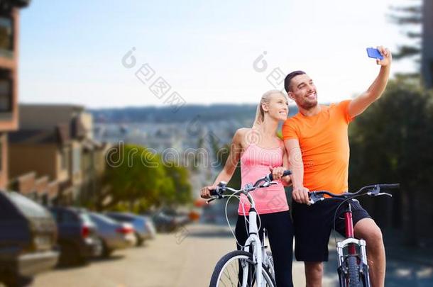 对和自行车迷人的自拍照在旁边智能手机