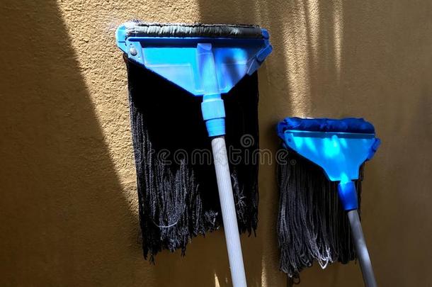 用拖把拖,恶劣的用拖把拖蓝色为洗涤干净的在上面房屋滑,用拖把拖日光浴