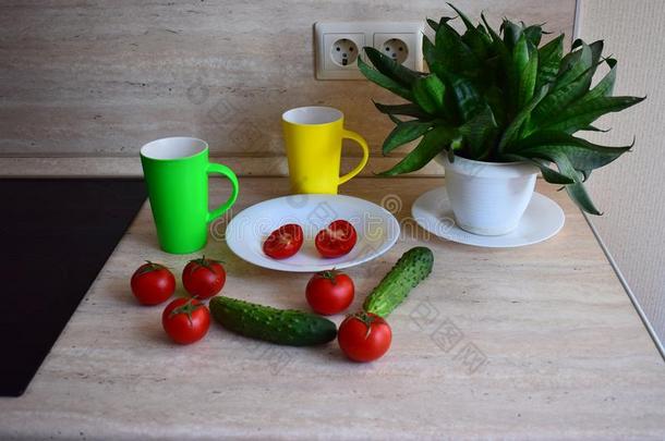 红色的成熟的番茄和绿色的黄瓜躺向指已提到的人厨房表.