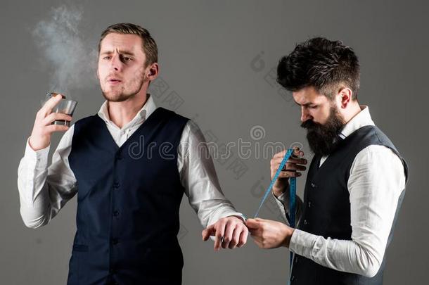 顾客,商人和傲慢的面容烟雪茄在期间裁缝