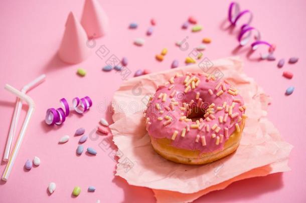 社交聚会.颜色鲜艳的含糖的圆形的光滑的油炸圈饼向粉红色的backg圆形的.