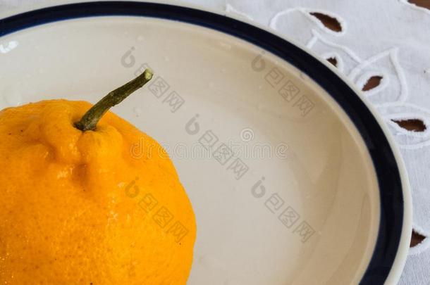 详述关于成熟的柑橘向白色的瓷盘.