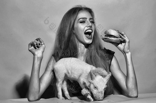 保护关于动物.女孩吃汉堡包和猪