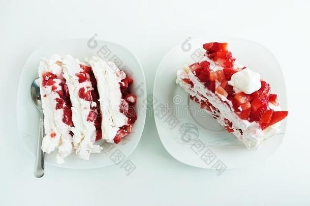 两个部分关于奶油水果蛋白饼蛋糕和草莓和乳霜向白色的