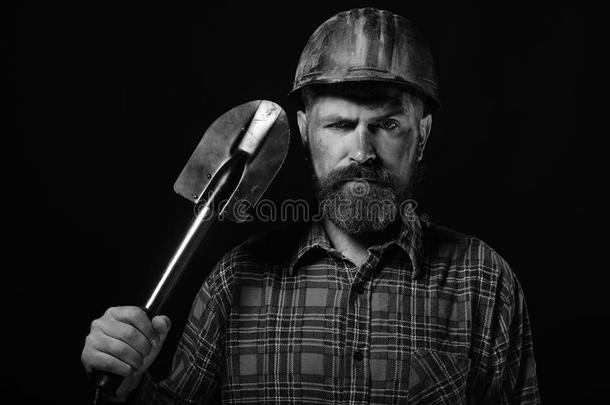工人和野蛮的影像穿着恶劣的头盔和保存铲子