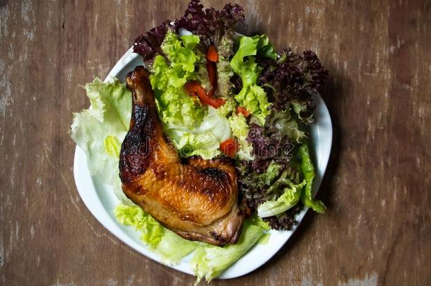一盘关于烤鸡股和新鲜的蔬菜向木制的英语字母表的第20个字母
