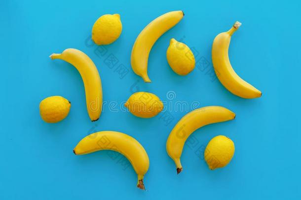 黄色的香蕉和柠檬向明亮的<strong>蓝色纸</strong>,时髦的平的放置.