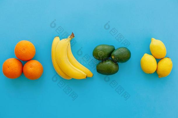 香蕉,橙,鳄梨和柠檬组向明亮的<strong>蓝色纸</strong>