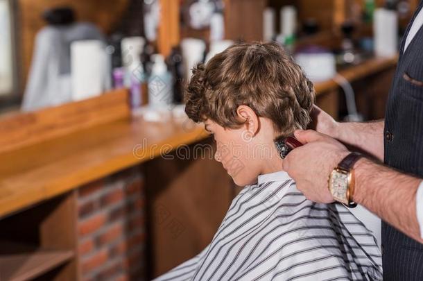 小的有卷发的小孩获得理发从理发师