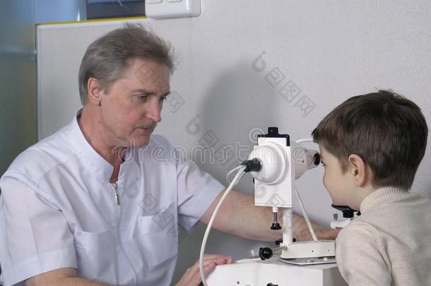 眼睛检查,验光师采用考试房间和年幼的男孩